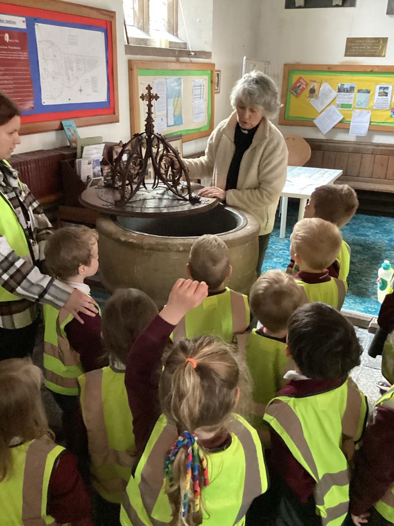 A visit to St Matthew's Church, Wookey Children with a vicar at a font